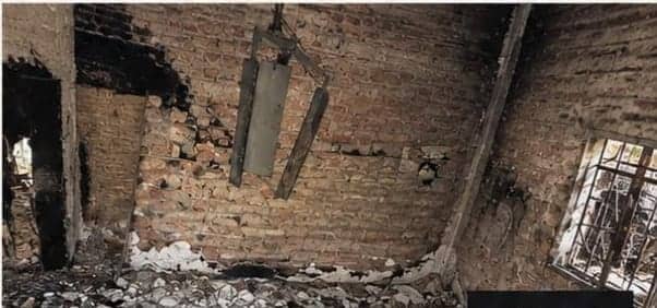 Una habitación sin techo. Las paredes quedaron de ladrillo desnudo y negro en un rincón, una viga de madera quemada cuelga del vacío y el piso está cubierto de escombros.